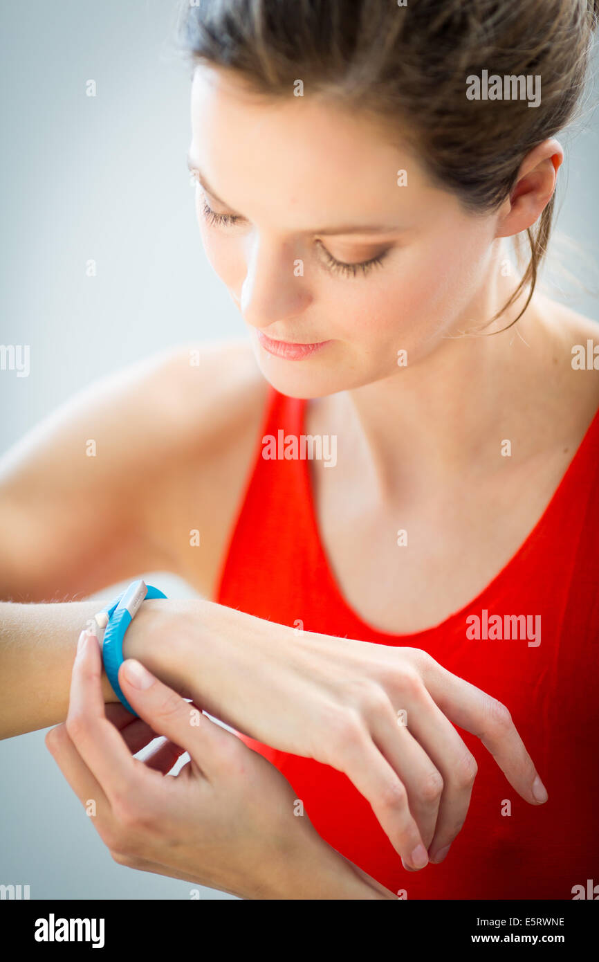 Woman wearing an UP® by Jawbone electronic wristband, sensor tracker ...