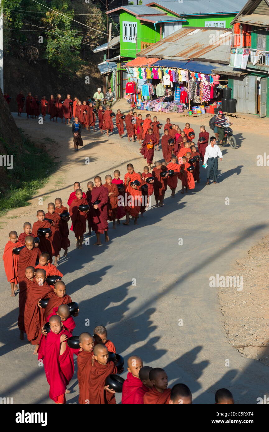 The abbott of Taungpulu Monastery (U Pyinnya Thiri), leading novice monks in alms collection in the morning through Mindat, Chin Stock Photo