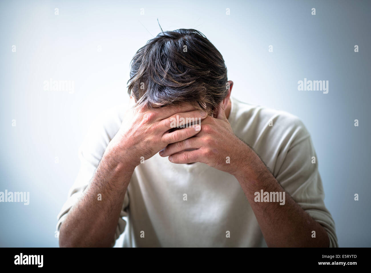 depressed-man-holding-his-head-in-his-hands-E5RYTD.jpg
