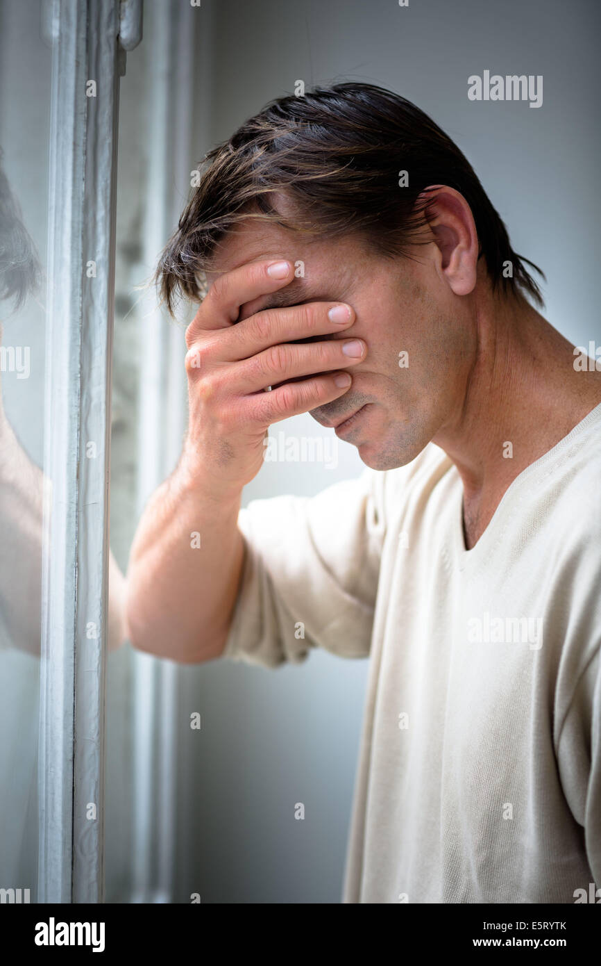 Depressed man holding his head in his hand Stock Photo - Alamy