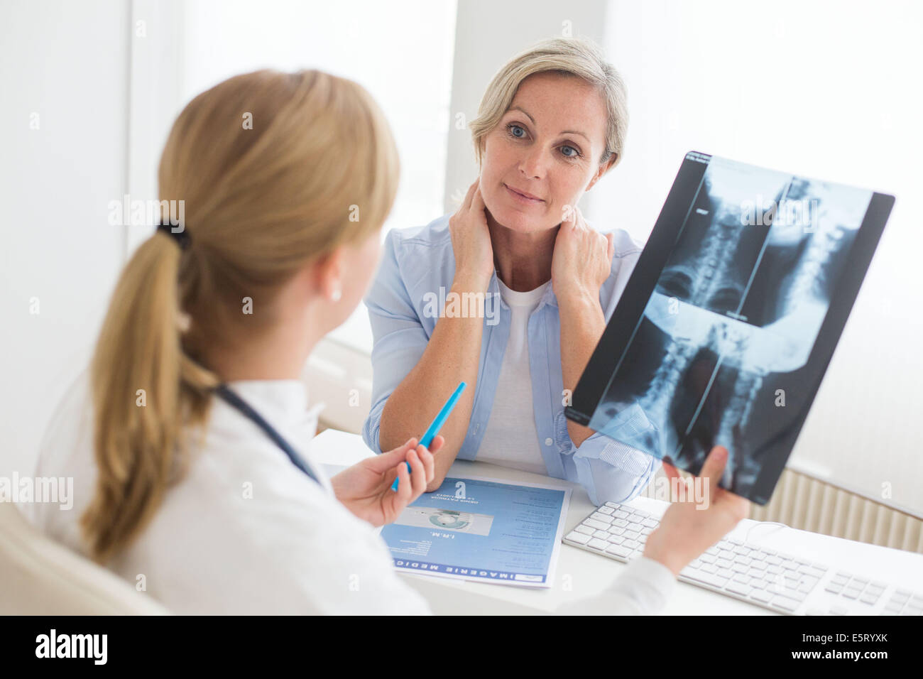 Doctor looking at a of the cervical spine x-ray of her patient. Stock Photo