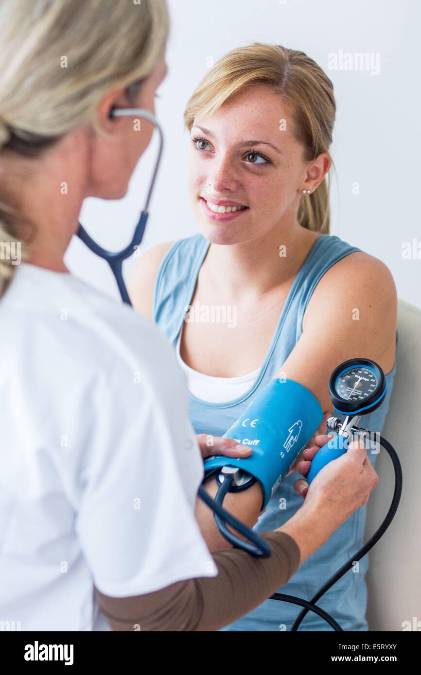 Doctor checking the blood pressure of a woman Stock Photo - Alamy