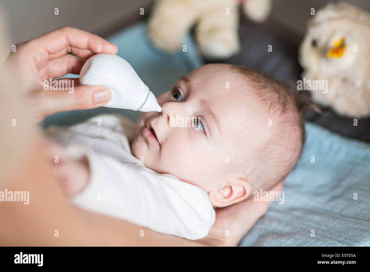 4 months old baby boy having his nose cleared with a nose-blower. Stock Photo