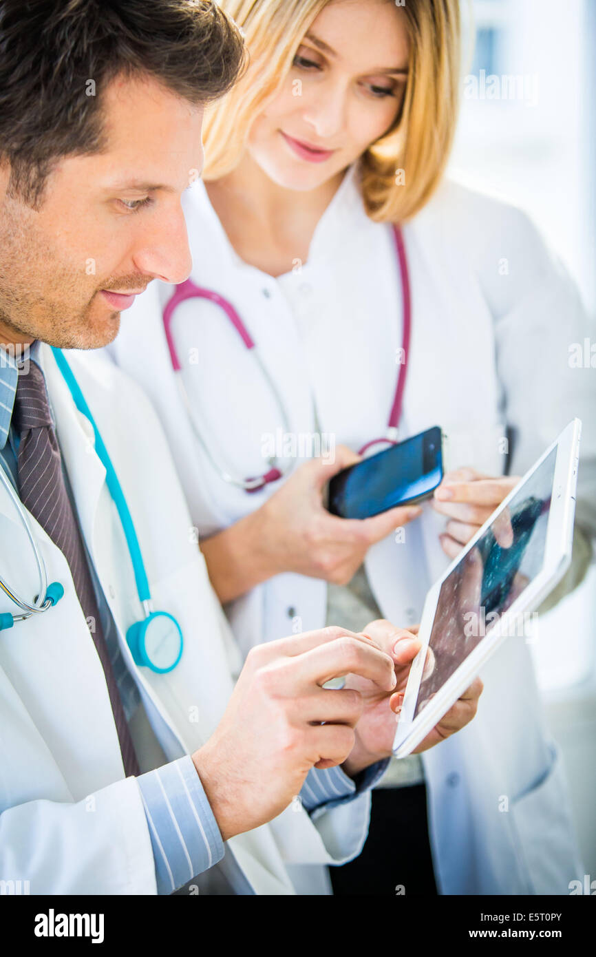 Doctors using a tablet PC and Iphone®. Stock Photo
