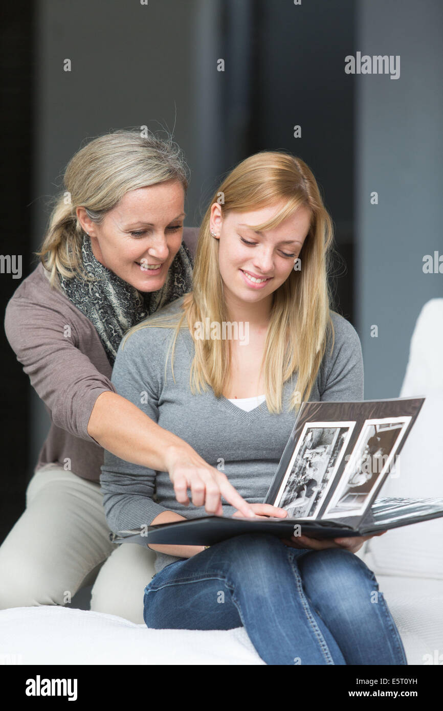 Teenage girl and her mother looking at photo album. Stock Photo