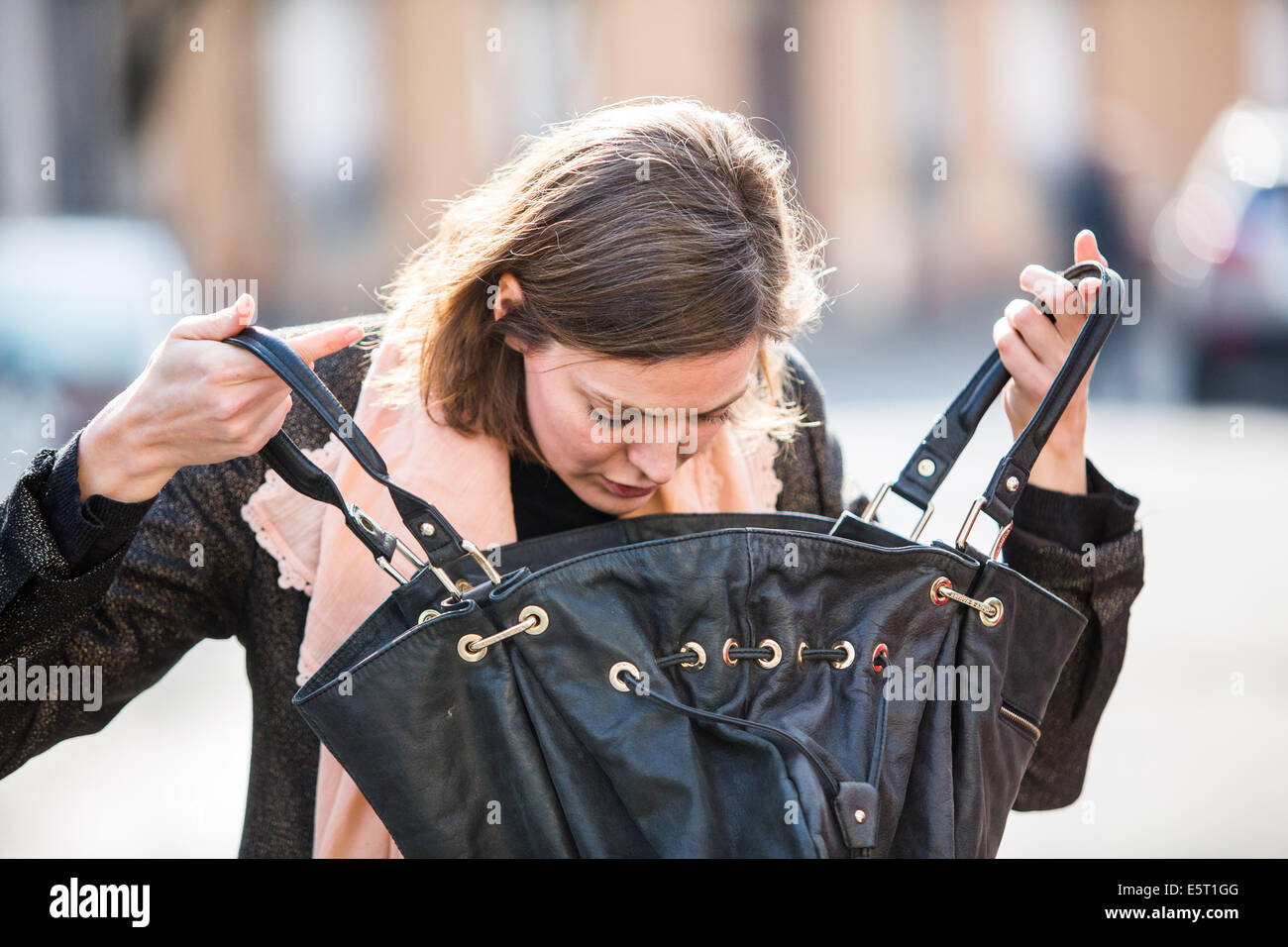 Woman looking into her handbag. Stock Photo