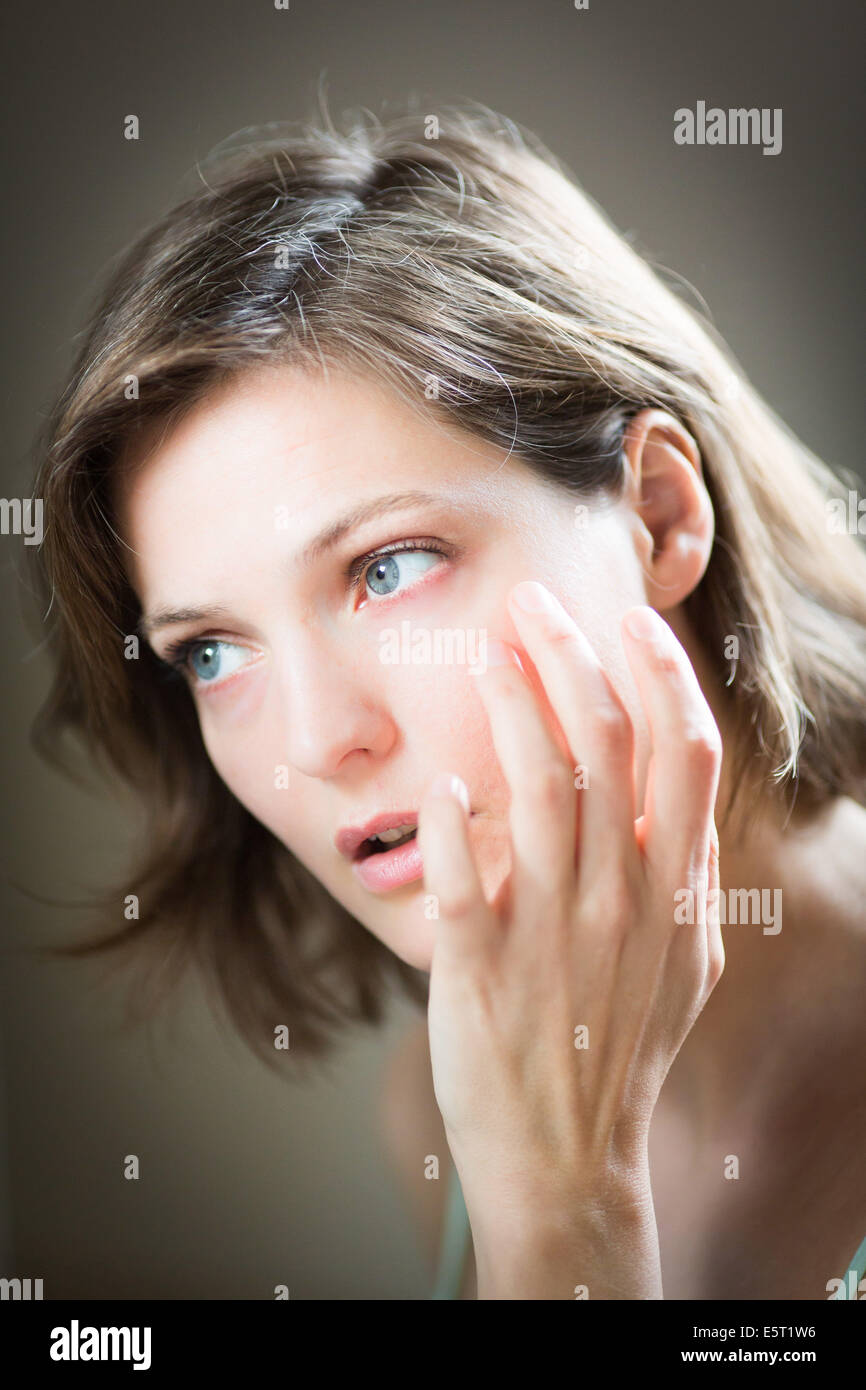 Woman checking her face in the mirror Stock Photo Alamy