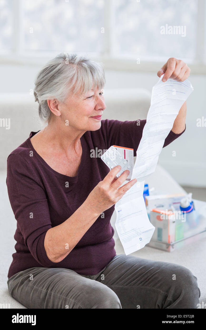 Woman reading medicine instruction sheet. Stock Photo