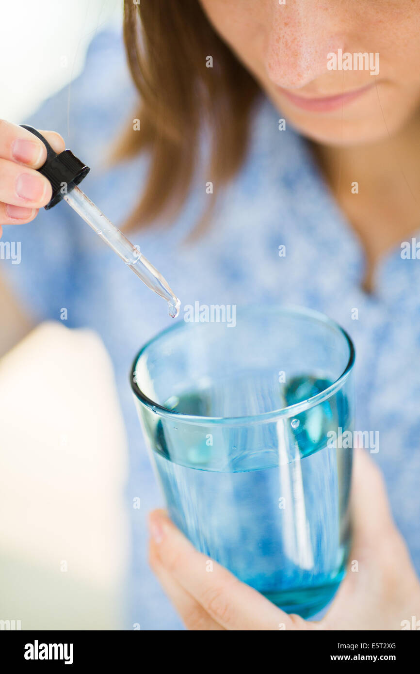 Woman taking drops of medicine. Stock Photo