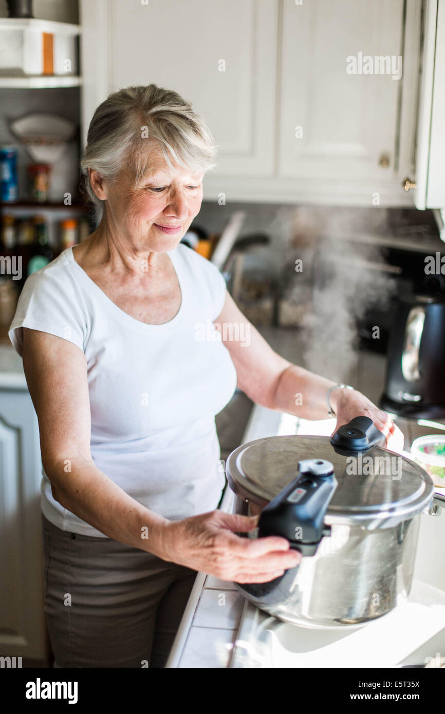 Senior woman using a pressure cooker Stock Photo Alamy