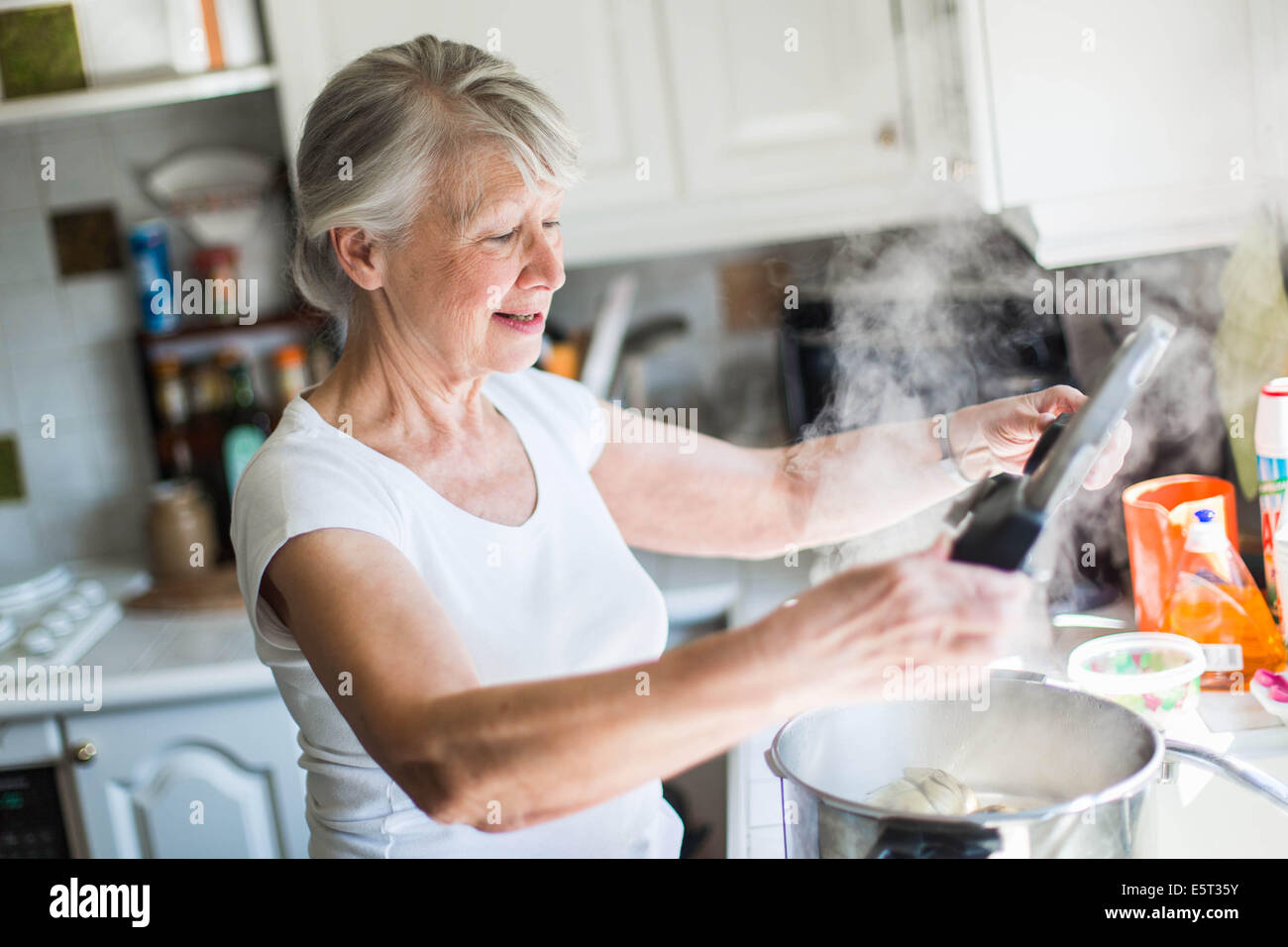 Senior woman using a pressure cooker Stock Photo Alamy