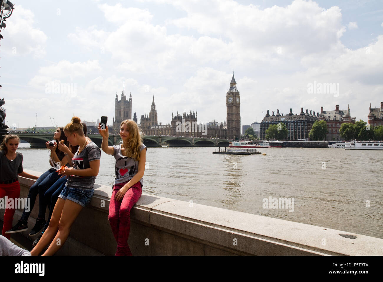 A young woman takes a selfie next to the River Thames in London Stock Photo