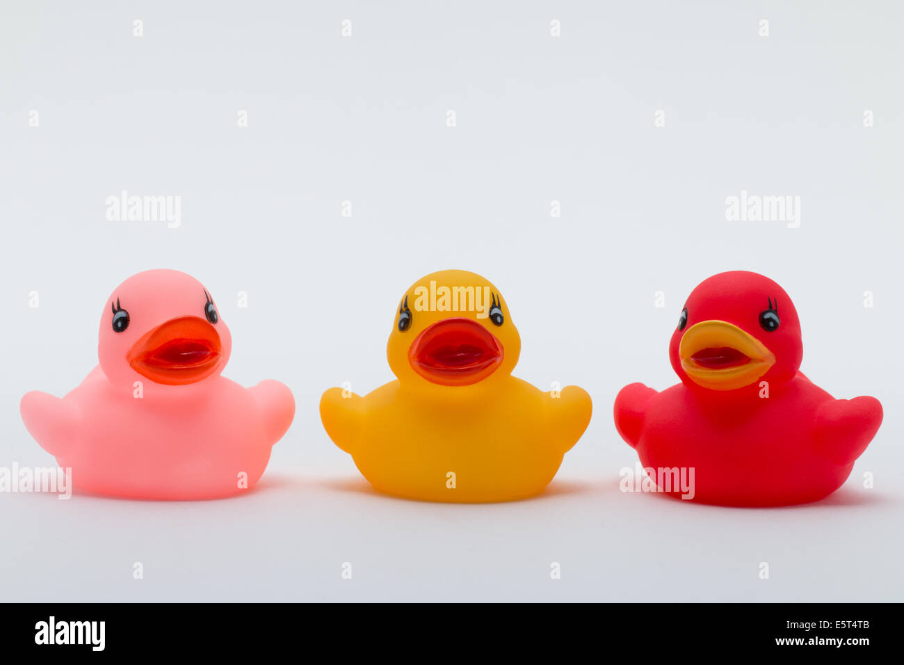 Three rubber ducks in different colors facing the viewer Stock Photo
