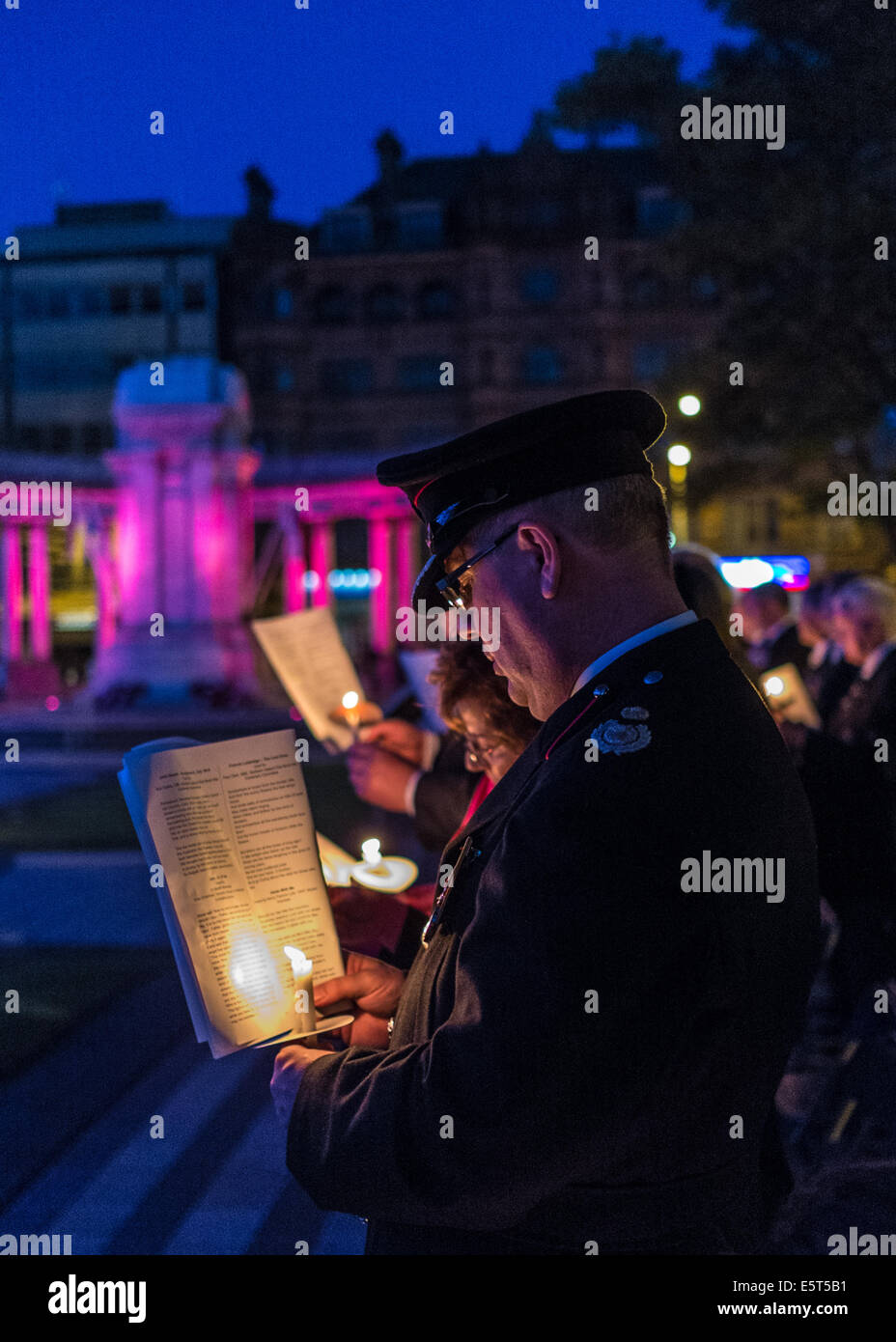 WW1 Candlelight vigil at Belfast City Hall.  Uniformed officer from Northern Ireland Fire Brigade stands with lighted candle. Stock Photo