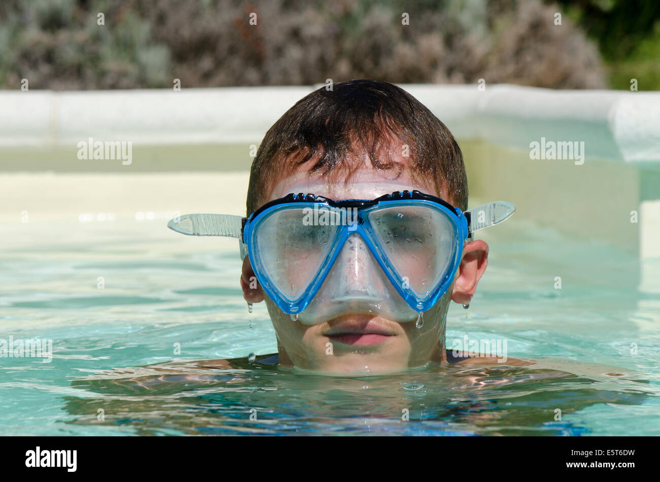 Teenager boy wearing diving mask or goggles in swimming pool Stock