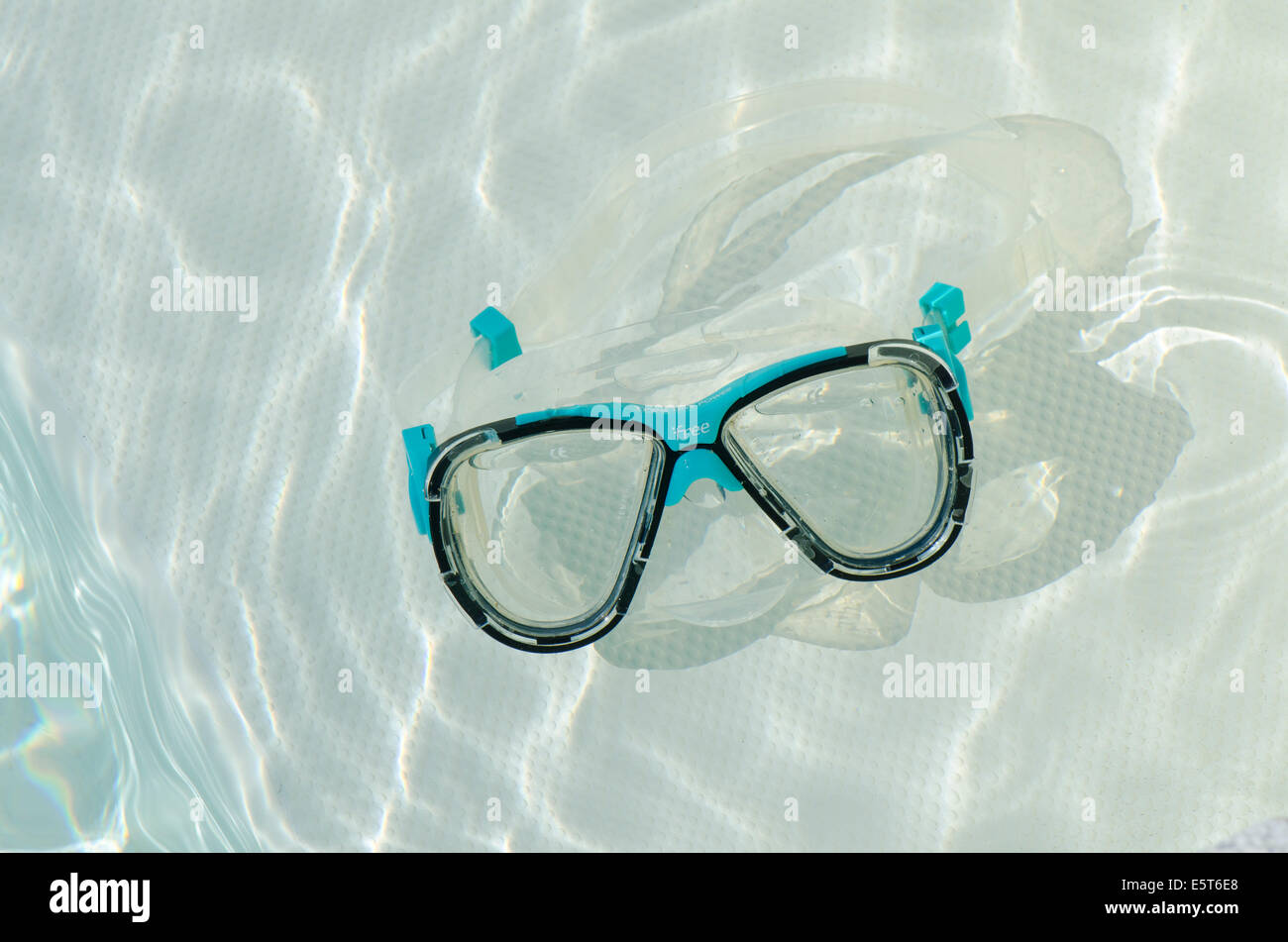 Diving mask or goggles floating in swimming pool. Stock Photo
