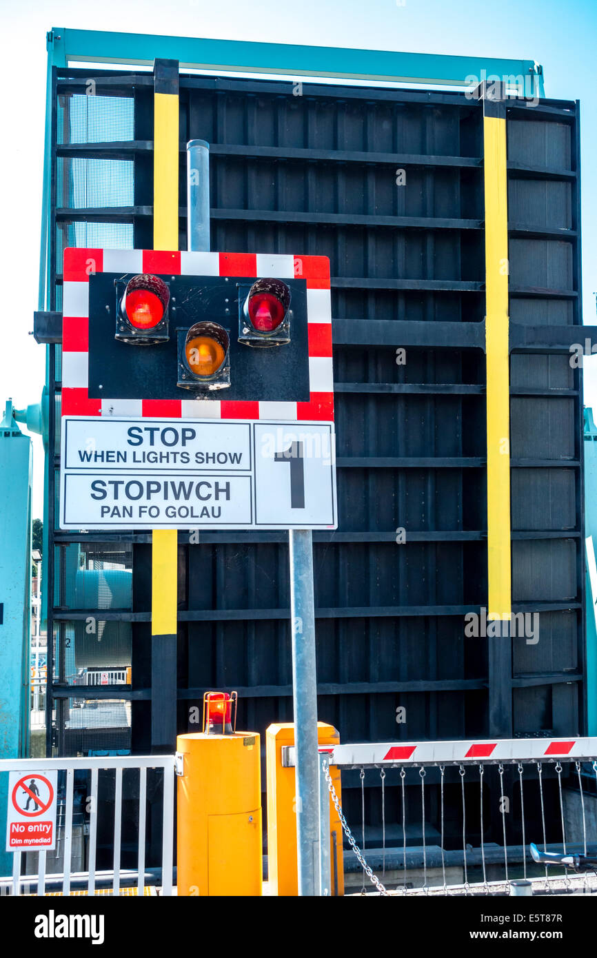 Stop barrier warning lights and raised bascule bridge across the locks in Cardiff Bay barrage Stock Photo