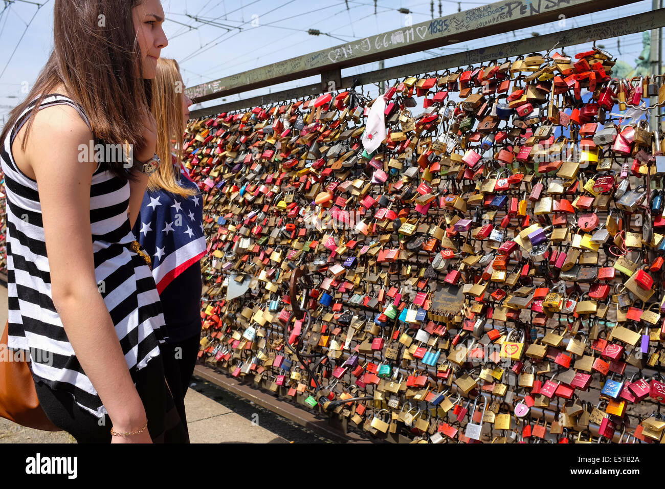 Teenagers looking at padlocks on the wall of love in the Hohenzollern Bridge in Cologne, Germany Stock Photo