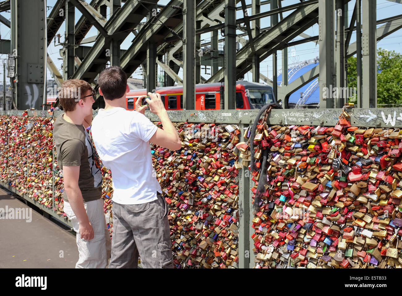 Boys looking at padlocks on the wall of love in the Hohenzollern Bridge in Cologne, Germany Stock Photo