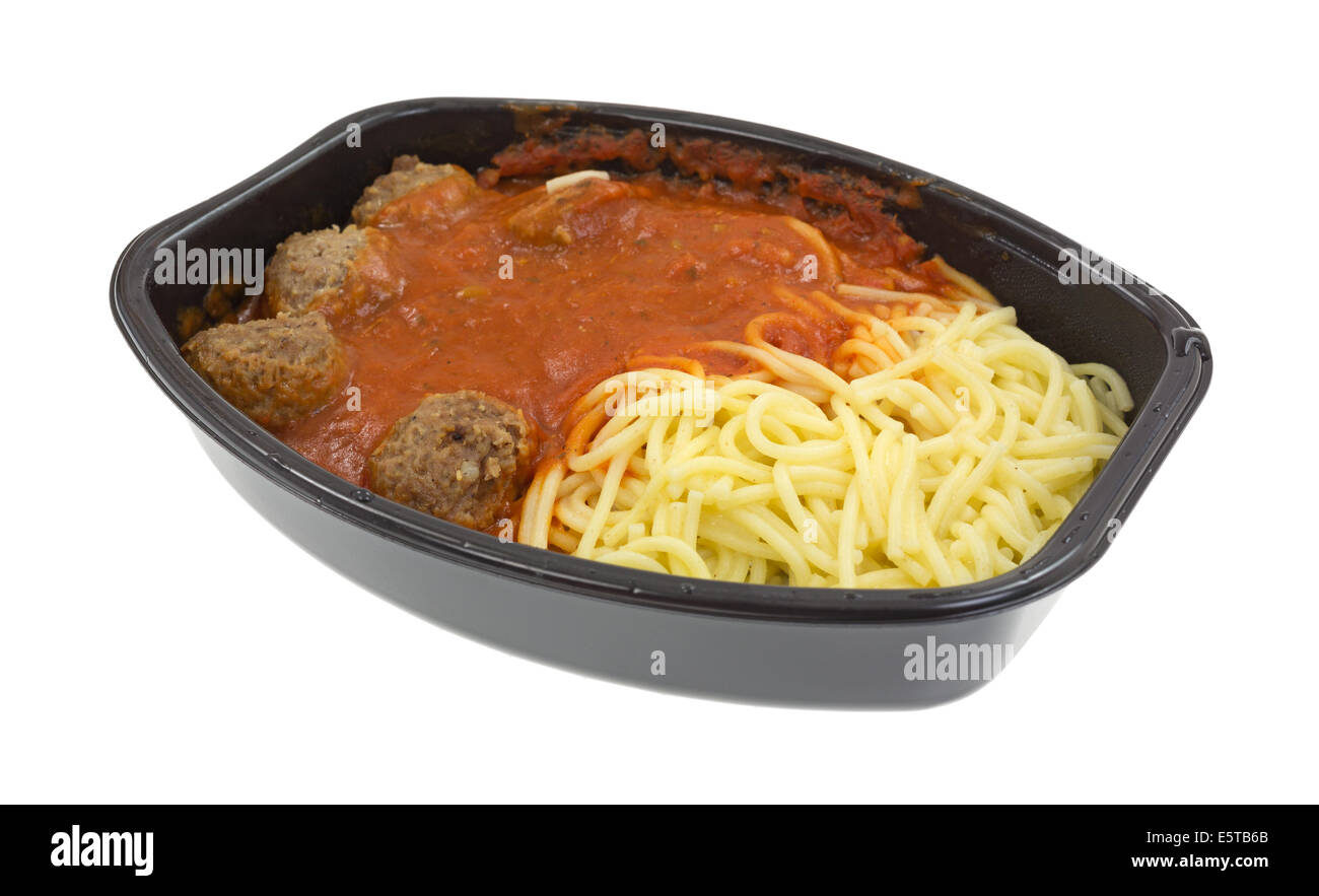 A freshly cooked spaghetti and meatball TV dinner in the black plastic tray on a white background. Stock Photo