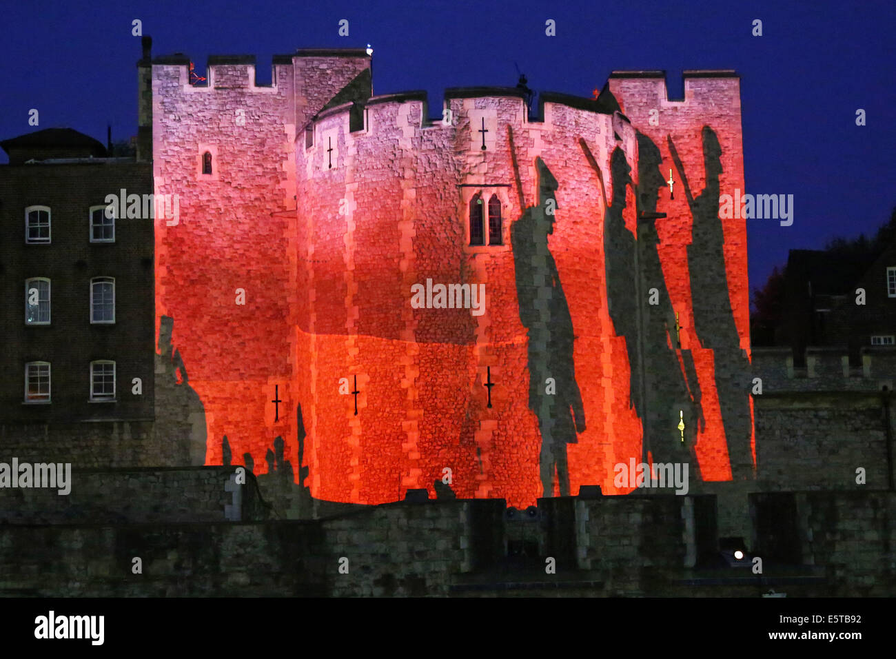 London, UK. 5th August 2014. The opening of the  Blood Swept Lands and Seas of Red artwork by Paul Cummins at the Tower of London. 888,246 ceramic poppies, each poppy representing a British or Colonial military fatality during the war, will fill the moat by November 11th. For the opening, battlefield images were projected onto the central tower while Tim Pigott-Smith read out names of the fallen during a 21 gun salute. The evening ended with the playing of the last post. Credit:  Paul Brown/Alamy Live News Stock Photo
