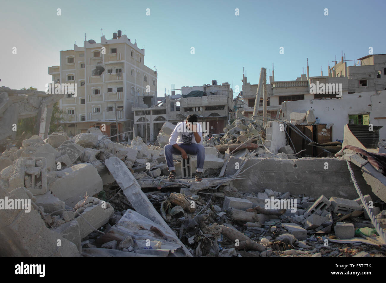 Gaza. 5th Aug, 2014. A Palestinian man sadly sits on the rubble of his ...