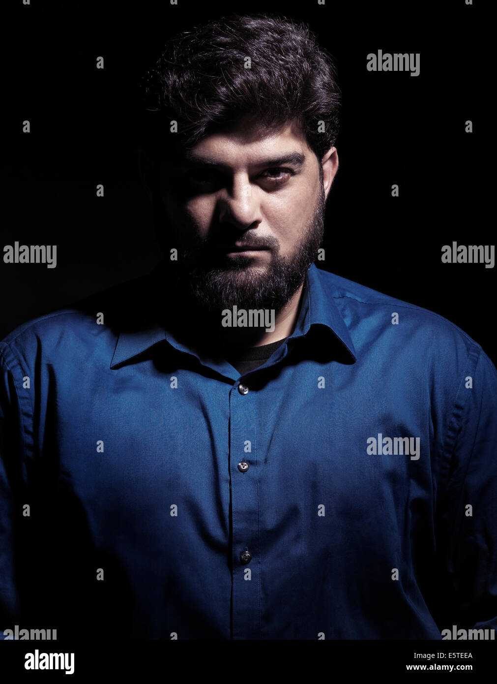 License available at MaximImages.com - Dramatic portrait of a pakistani man looking at the camera isolated on black background Stock Photo