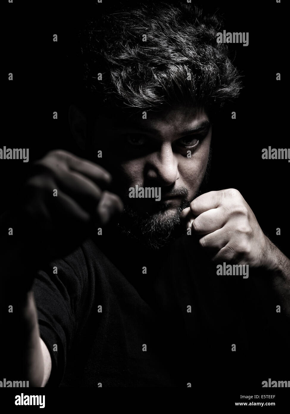 Dramatic portrait of a man in a fighting stance with fists in front of his face Stock Photo