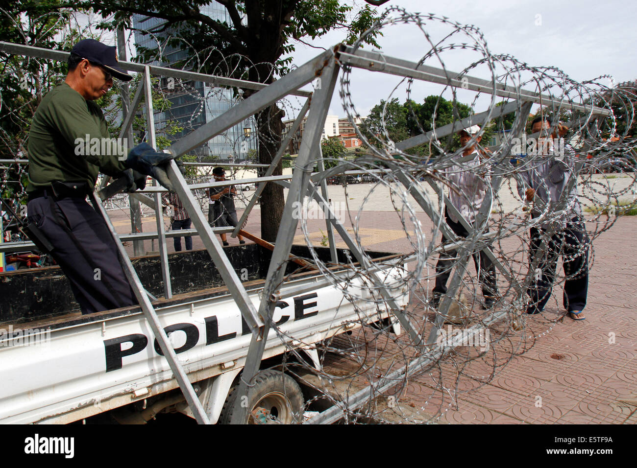 Phnom Penh, Cambodia. 6th Aug, 2014. Policemen remove razor wire from the Freedom Park in Phnom Penh, Cambodia, Aug. 6, 2014. The Cambodian authorities reopened the Freedom Park, a protest-designated site, a day after the opposition's 55 politicians were sworn in as lawmakers. Credit:  Sovannara/Xinhua/Alamy Live News Stock Photo