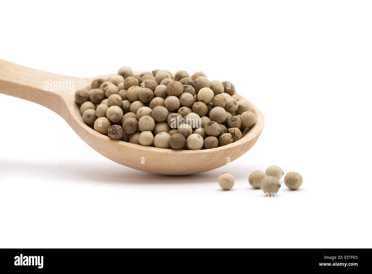 white peppercorns in wooden spoon Stock Photo