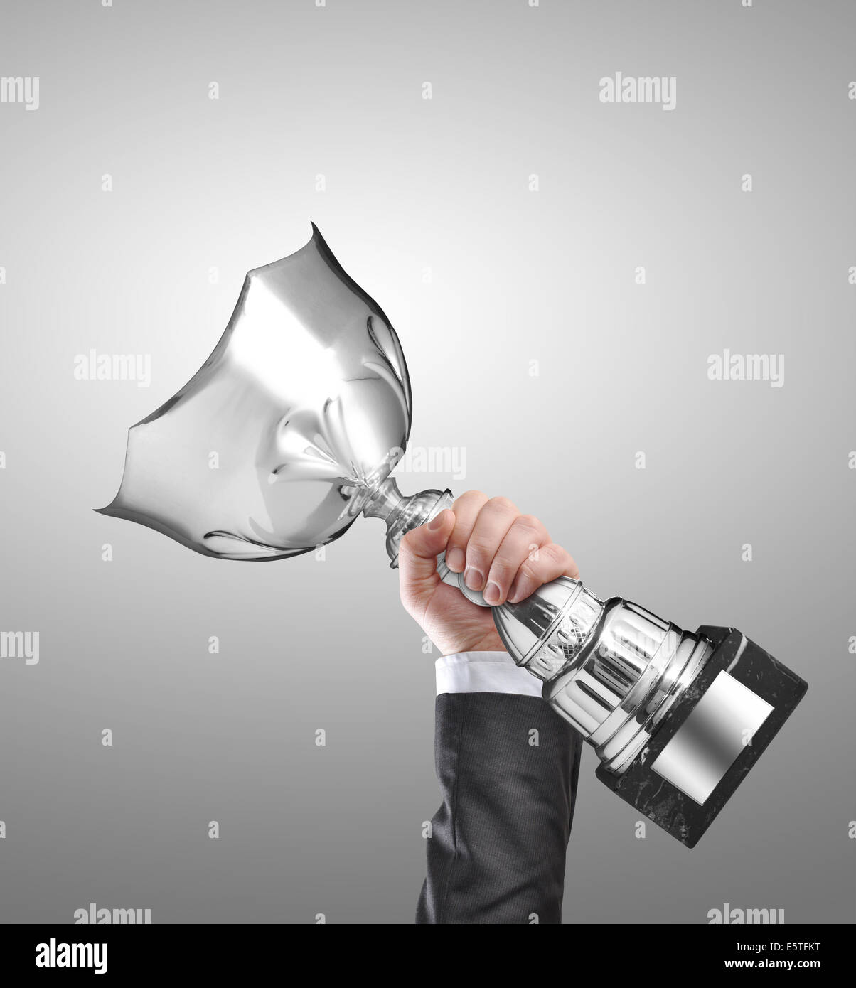 Businessman holding a champion silver trophy Stock Photo