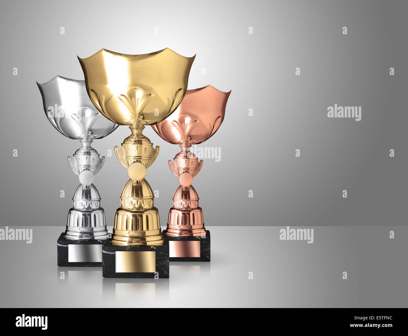 golden, silver and bronze trophies on gray background Stock Photo