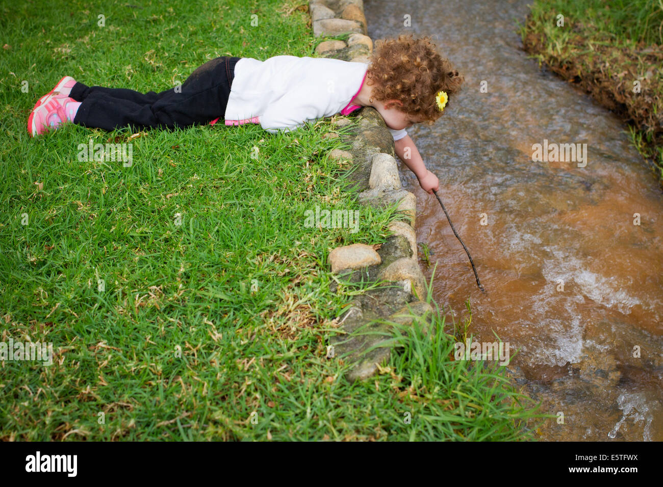 Little girl playing by a stream Stock Photo