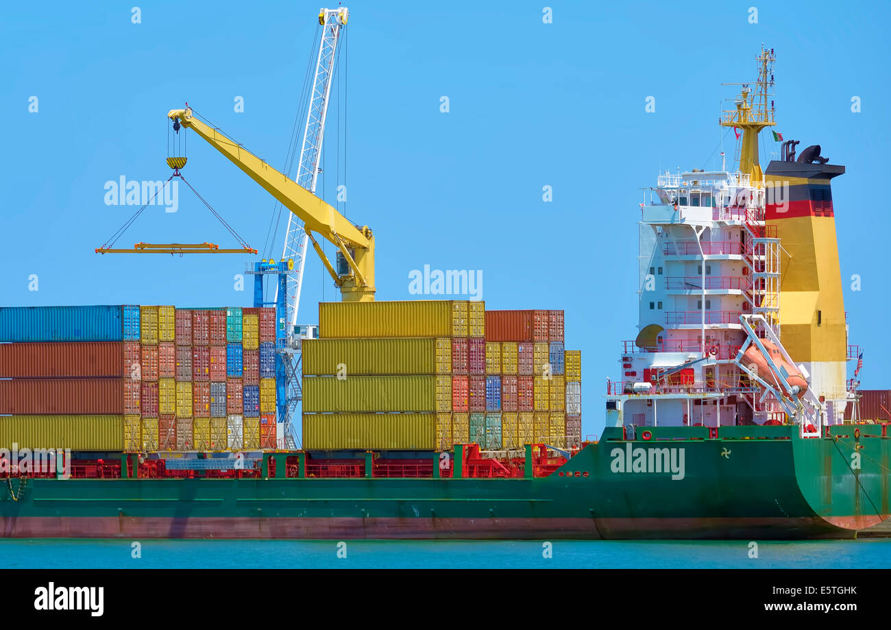 Crane loading containers on a ship in a harbor industrial Stock Photo ...