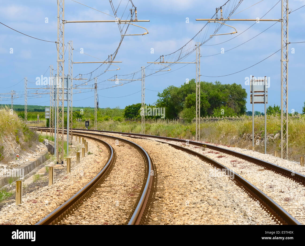 electrified railway tracks - view of a double curved track Stock Photo