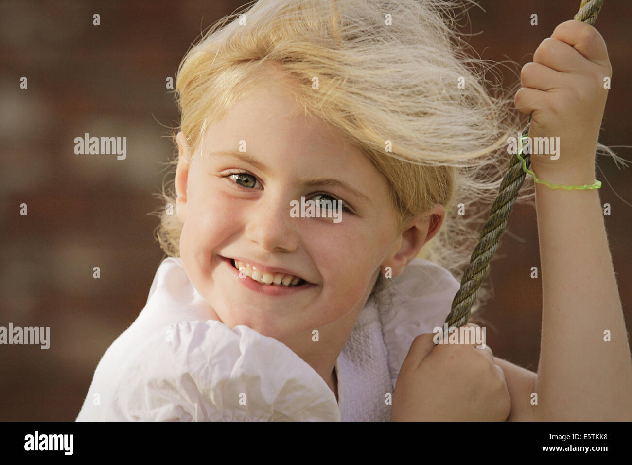 Pretty blond girl on a swing Stock Photo