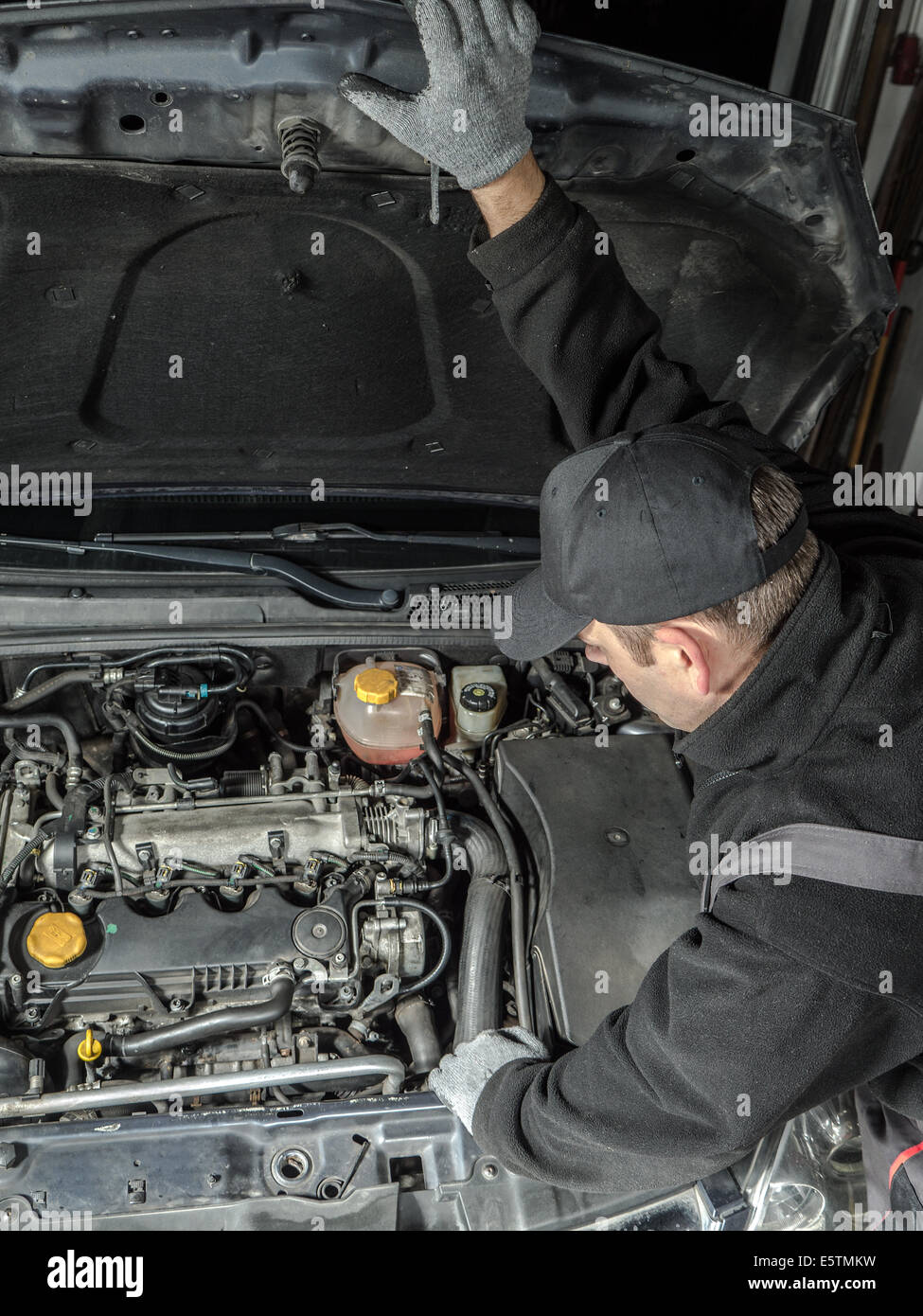 Auto mechanic inspecting car engine compartment Stock Photo