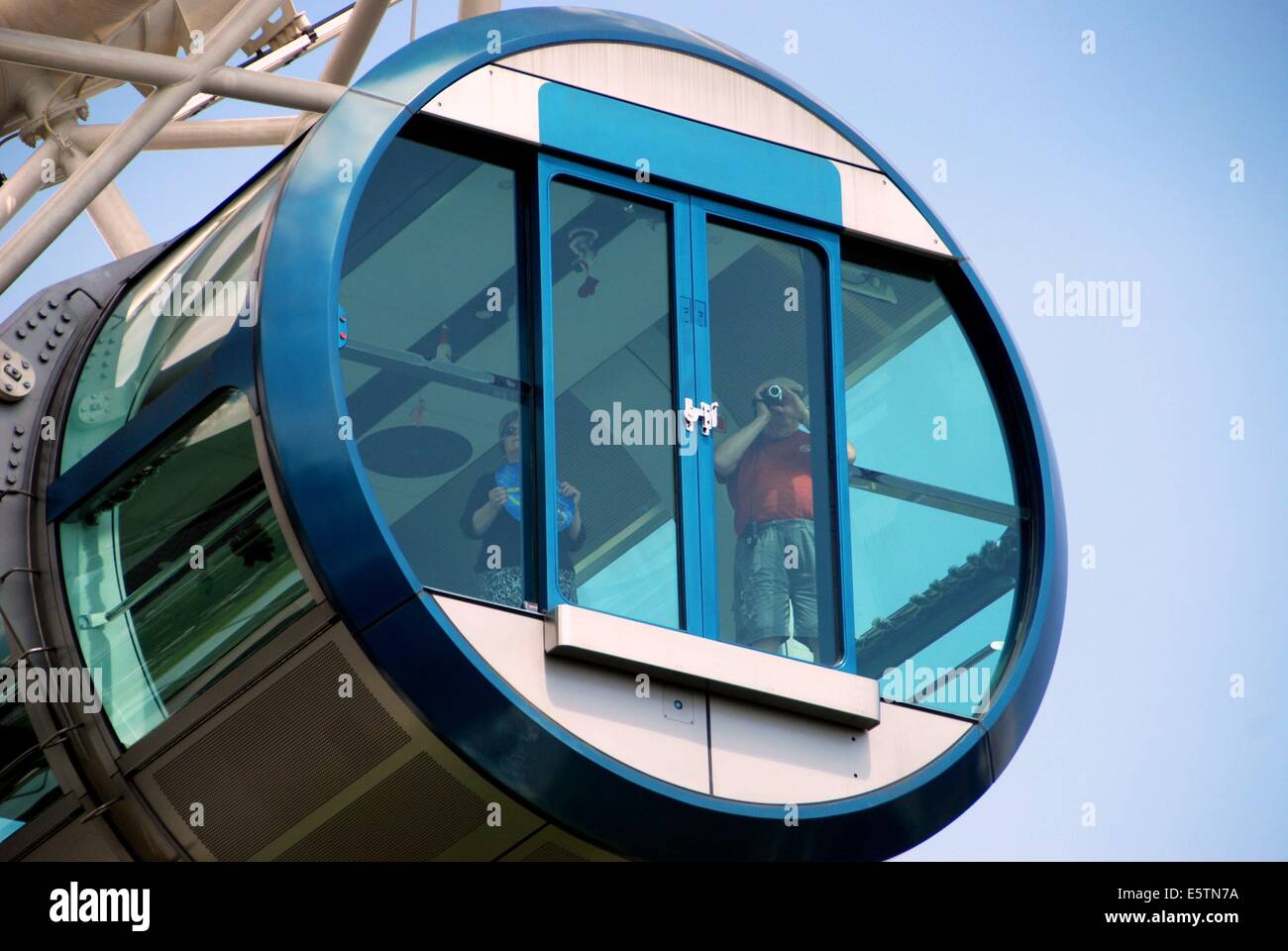 SINGAPORE:  Man takes photos during his 30 minute ride on the 541' high Singapore Flyer observation wheel Stock Photo