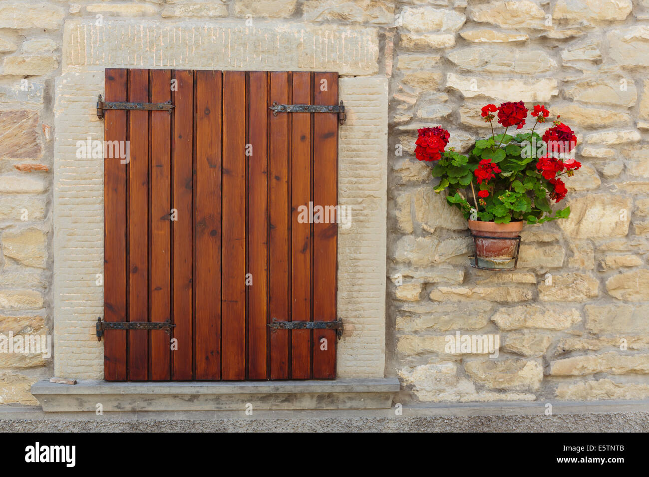 Window in an old house decorated with flower pots and flowers Stock Photo