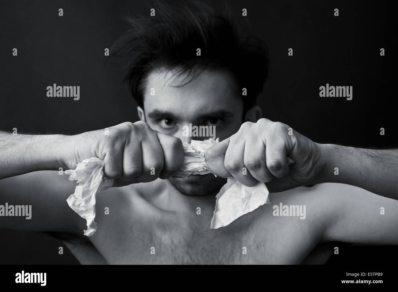 Portrait of a young man tearing paper Stock Photo Alamy