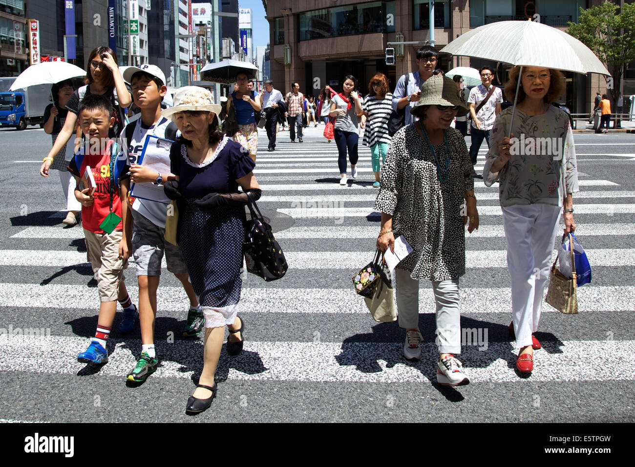 Tokyo, Japan. 6th Aug, 2014. Pedestrians walk under the hot