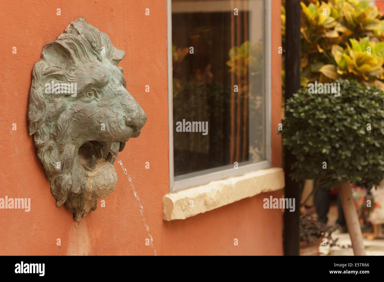 Statue of lion heads spout water Stock Photo - Alamy