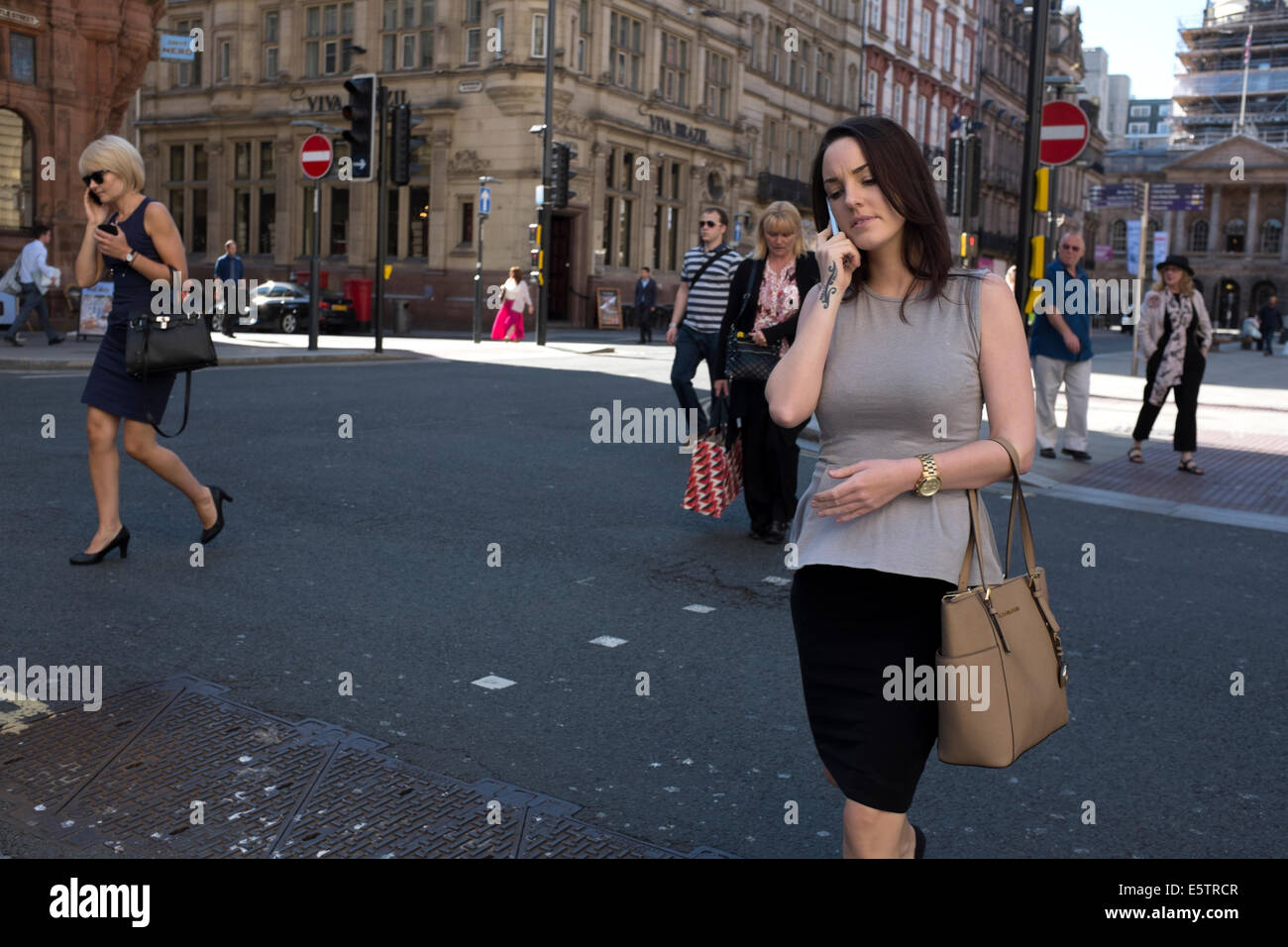 Business woman on phone crossing road business area Stock Photo