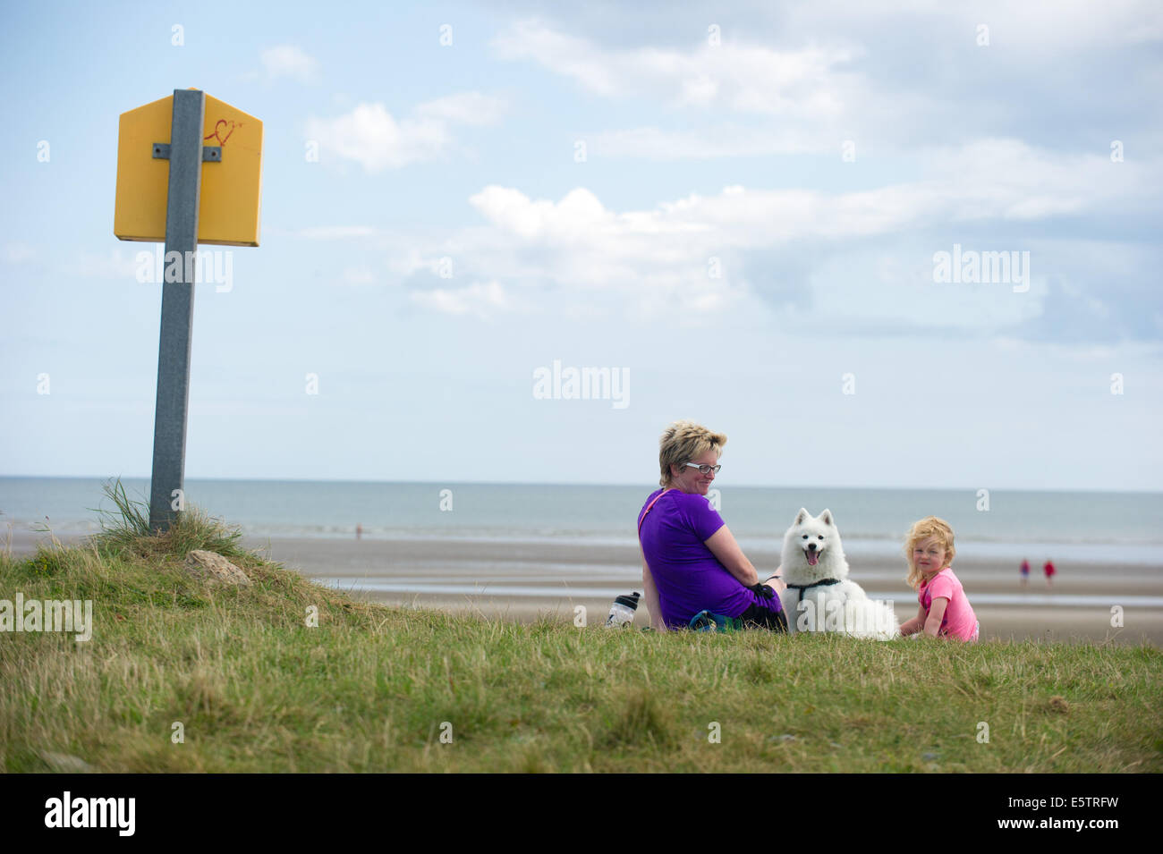 Port beach, County Louth, Ireland. 6th August, 2014. Karen Winters from Clogherhead, County Louth with her daughter Lucille and dog 'Lucky', a Japanese Spitz on Port beach, County Louth,Ireland. Credit:  Barry Cronin/Alamy Live News Stock Photo