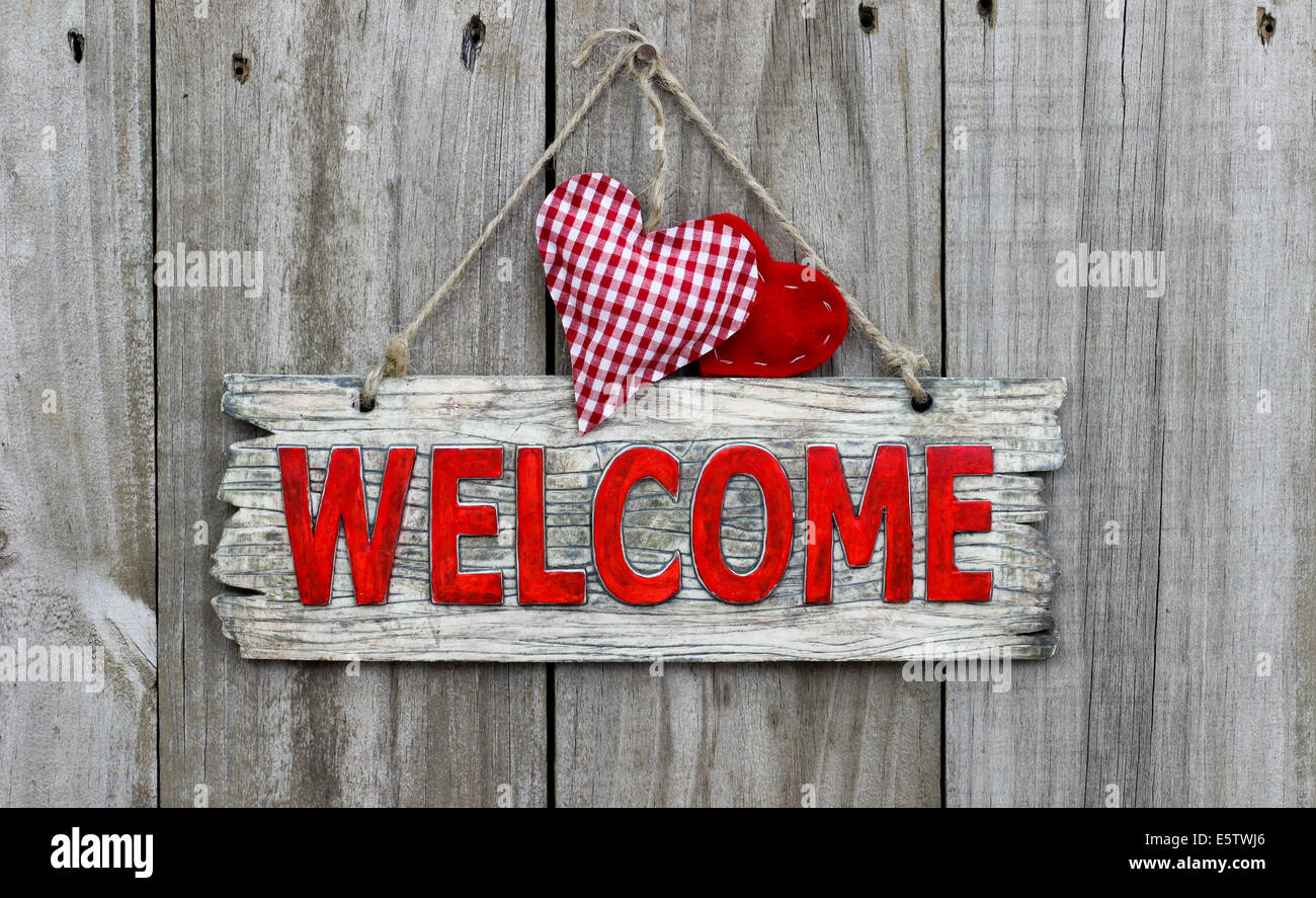 Red welcome sign with red checkered hearts on wooden background Stock