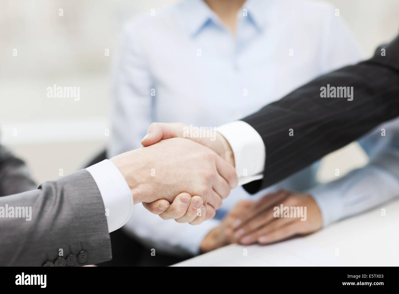 two businessmen shaking hands in office Stock Photo - Alamy