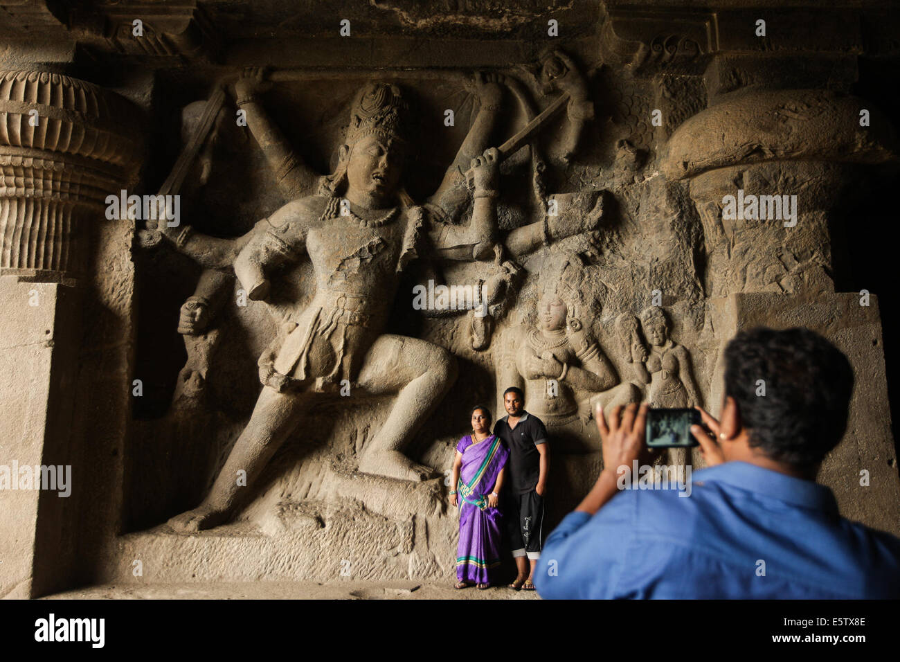 Maharashtra, India. 6th Aug, 2014. Tourists visit the Hindu stone carvings at the ellora caves near Aurangabad in Maharashtra, India, Aug. 6, 2014. The 34 monasteries and temples, extending over more than 2 km, were dug side by side in the wall of a high basalt cliff, not far from Aurangabad, in Maharashtra. Ellora, with its uninterrupted sequence of monuments dating from A.D. 600 to 1000, brings the civilization of ancient India to life. Not only is the Ellora complex a unique artistic creation and a technological exploitation but, with its sanctuaries devoted to Buddhism, Hind Stock Photo