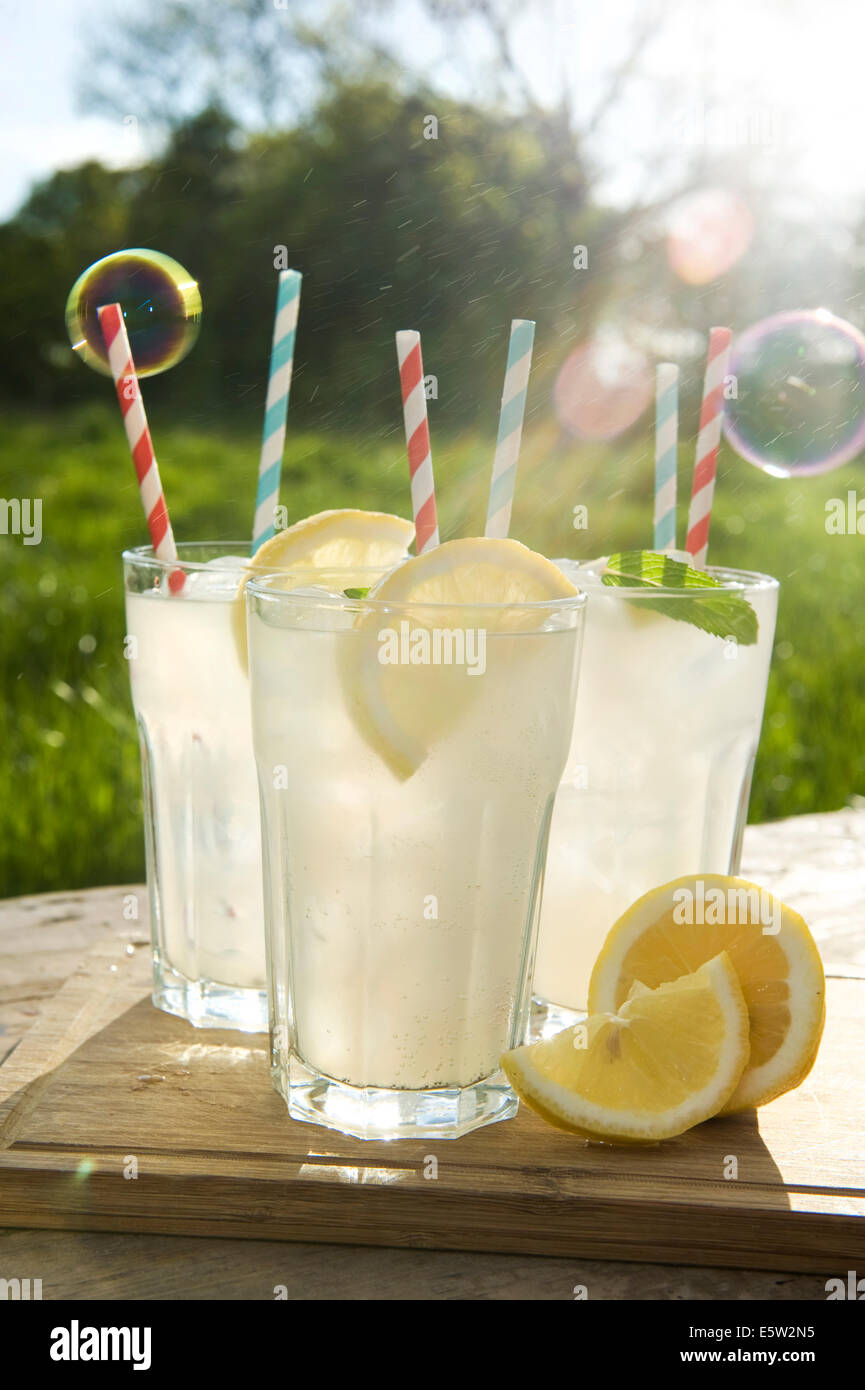 Homemade lemonade in tall glasses with straws on a summers evening in