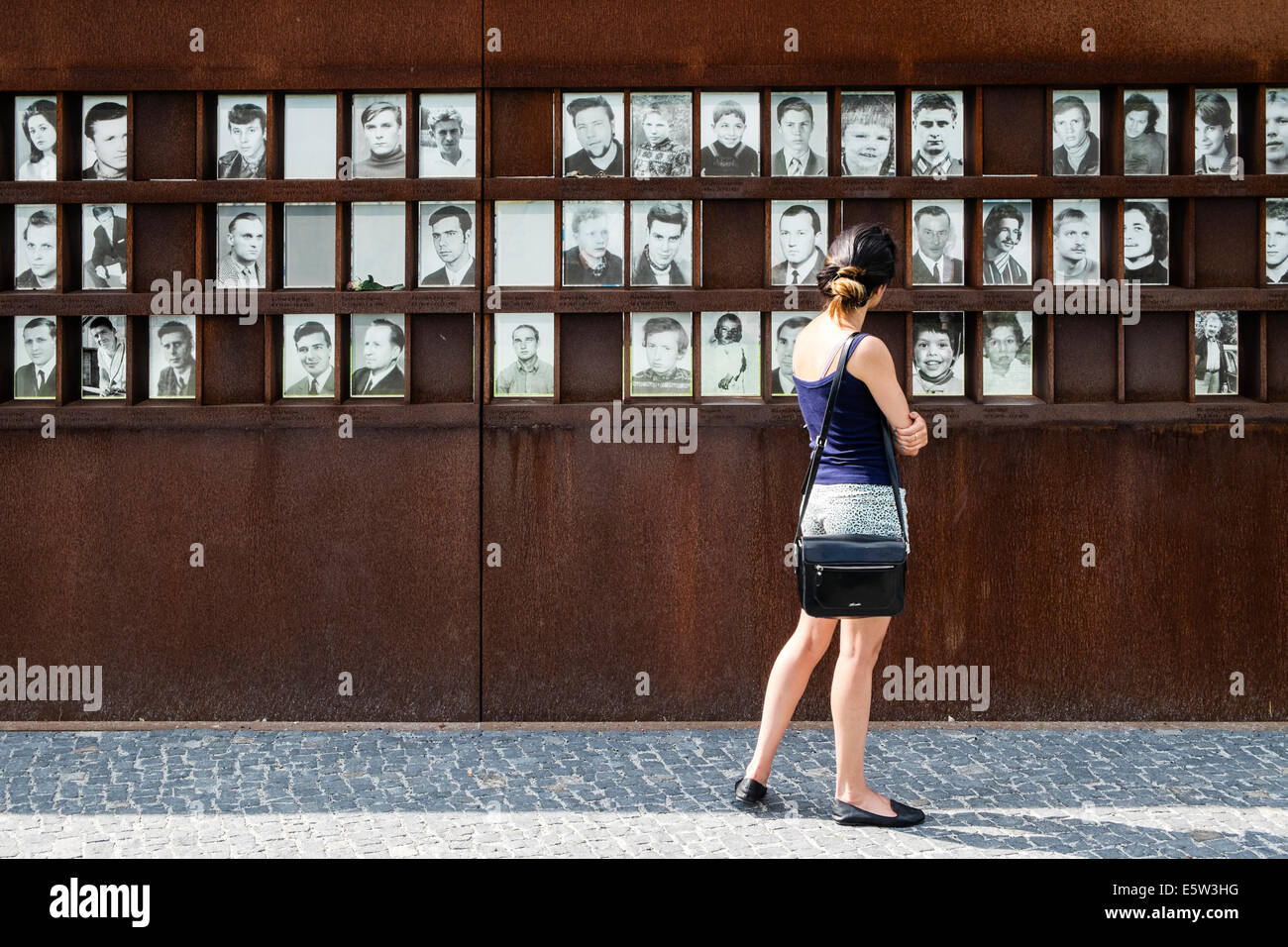 Woman looking at photographs of victims of escape attempts across Berlin Wall, Bernauer Strasse Memorial Park in Berlin Germany Stock Photo
