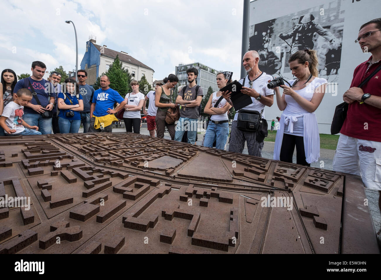 Tour group studies route of Berlin Wall from model at memorial park on Bernauer Strasse in Berlin Germany Stock Photo